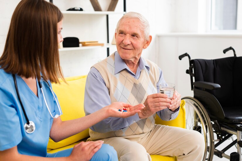 young nurse giving medicine to elderly man