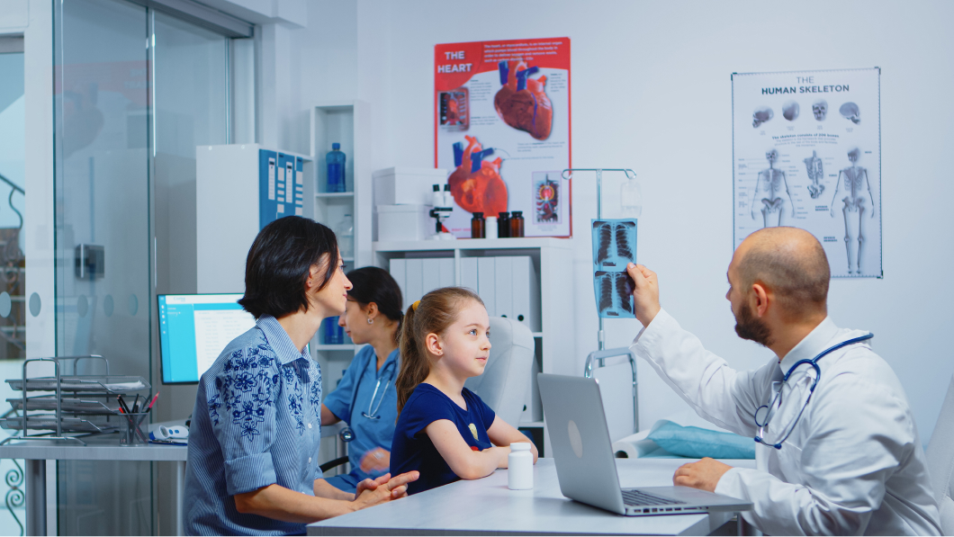 doctor and patients looking at x-ray sitting in medical office