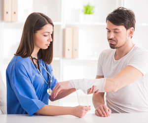 nurse applying bandage on patient's arm