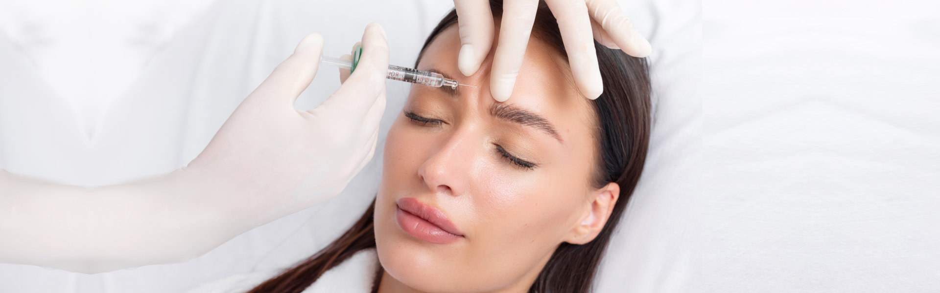 woman recieving injection of anti-aging botox filler to forehead