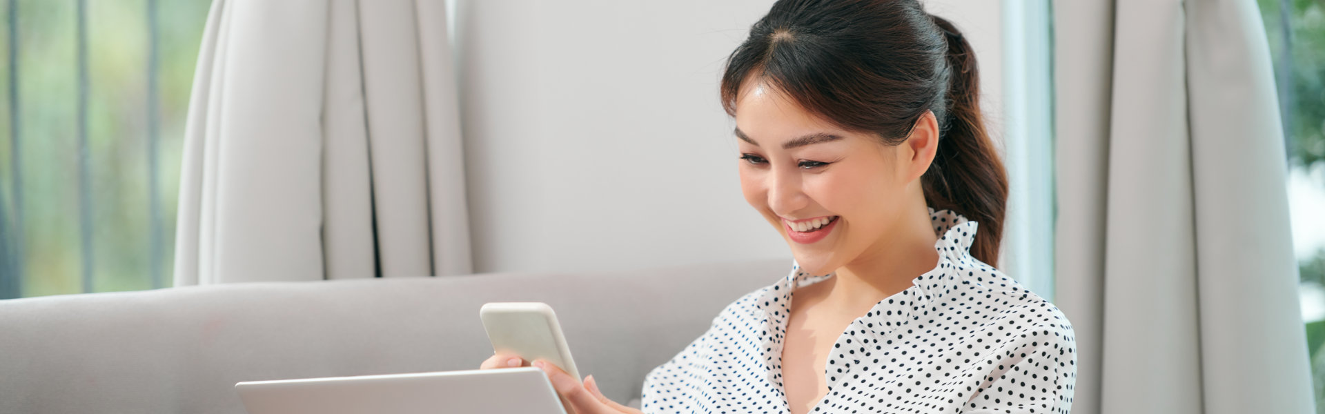 woman using mobile phone and laptop